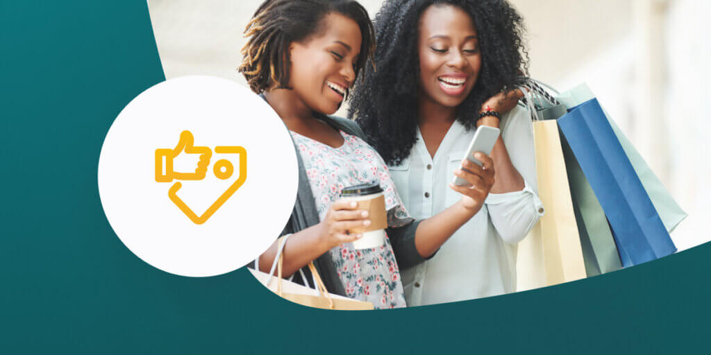 Women looking at mobile phone while shopping.